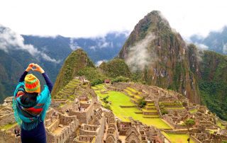 Image of a woman facing and overlooking Machu Picchu