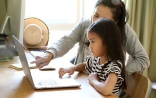 Mother and child attending English class in front of the computer