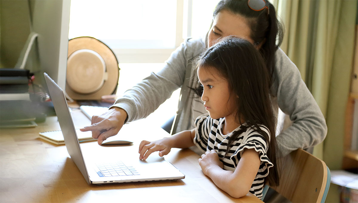 Mother and child attending English class in front of the computer